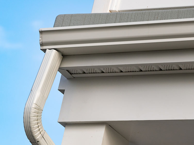 Close-up of a slightly gray seamless gutter systems on the fascia of a residential home